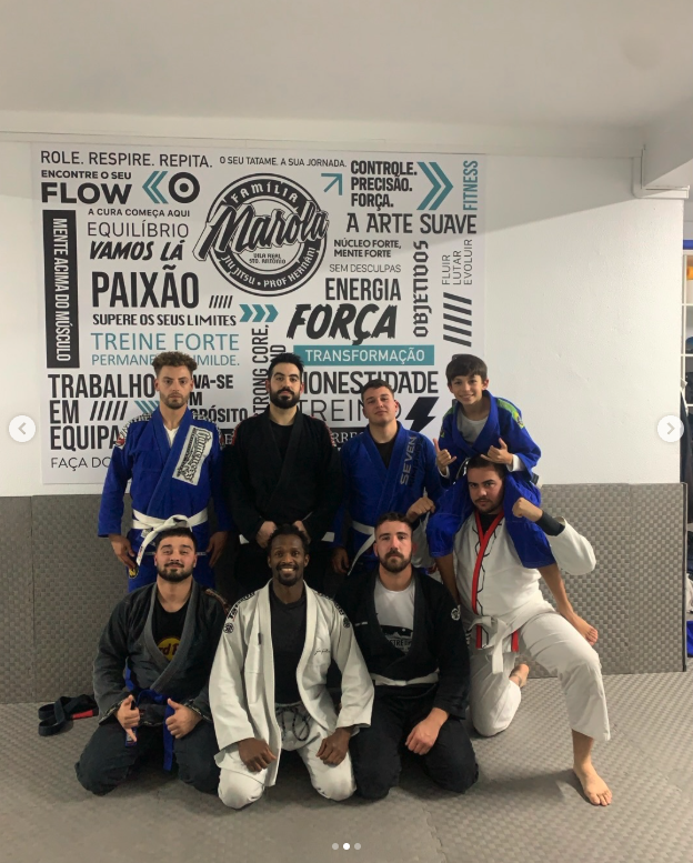 Equipa de Jiu-Jitsu com aluno jovem nos ombros