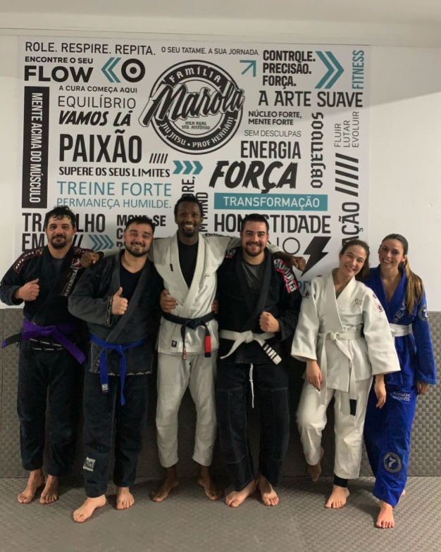 Turma de Jiu-Jitsu adultos com faixas visíveis